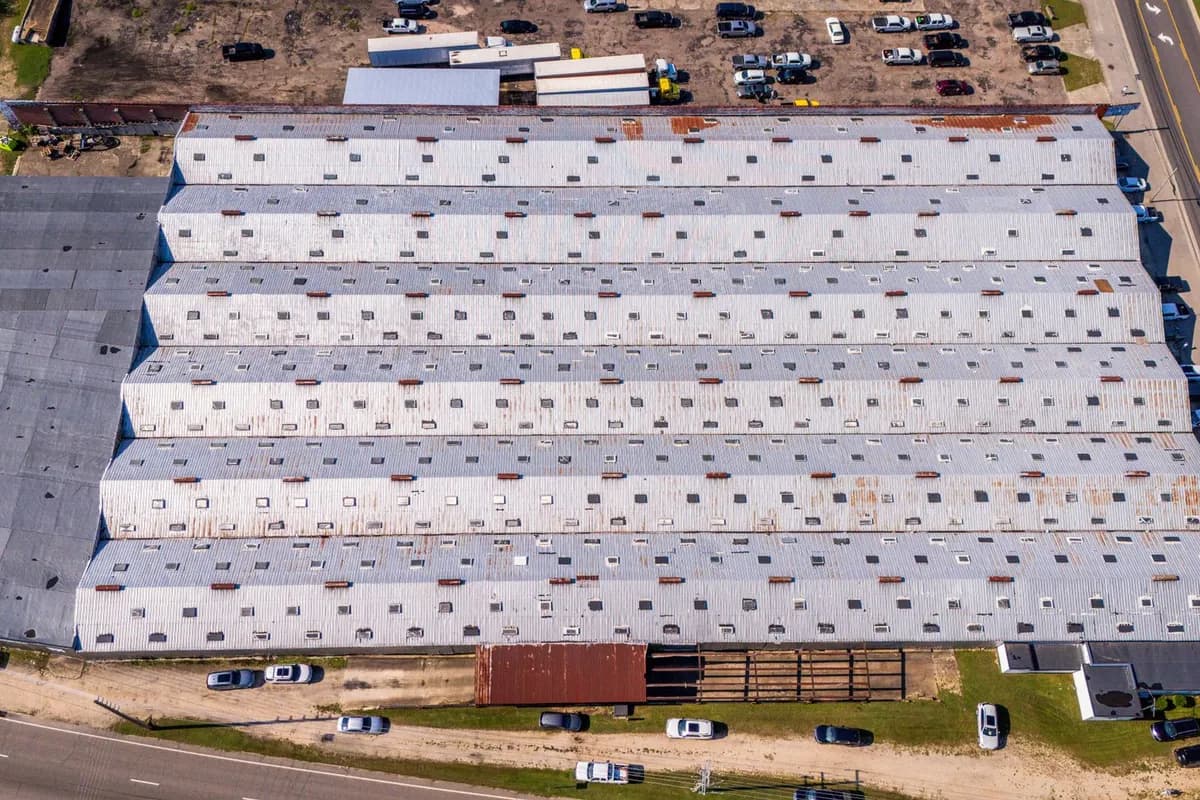 Aerial view of a large industrial warehouse with an expansive low-slope roof
