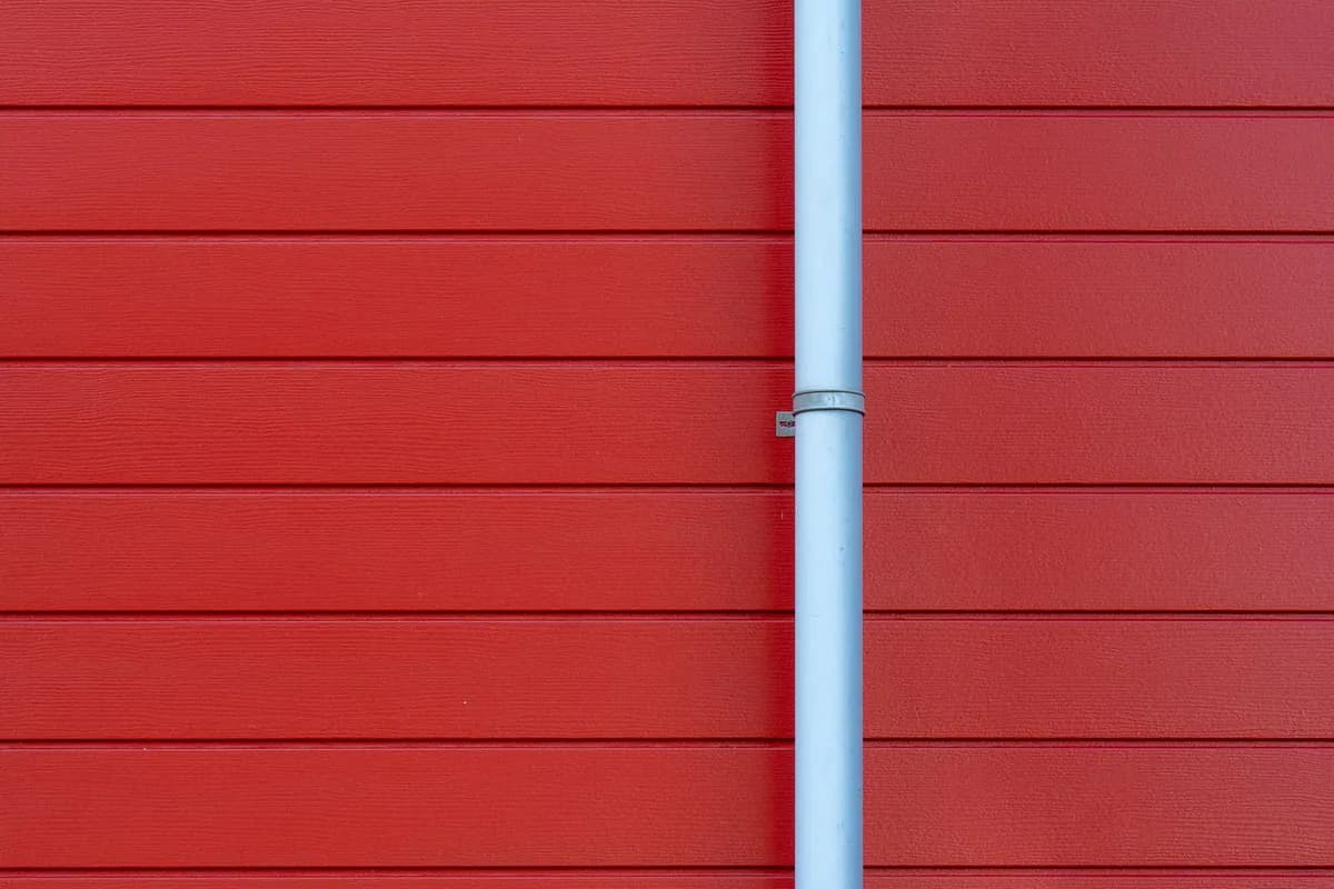 Rain gutter and downspout running along an exterior wall