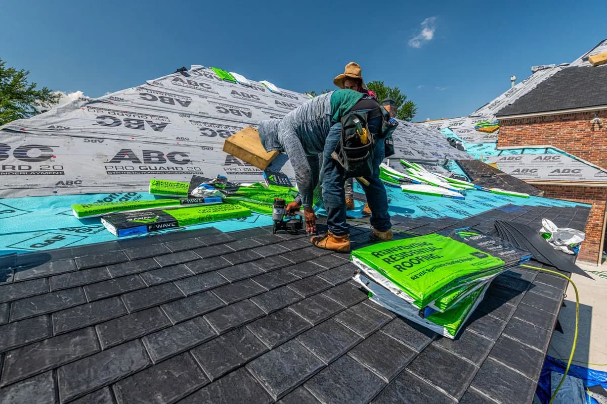 Workers installing a new roof on a brick house